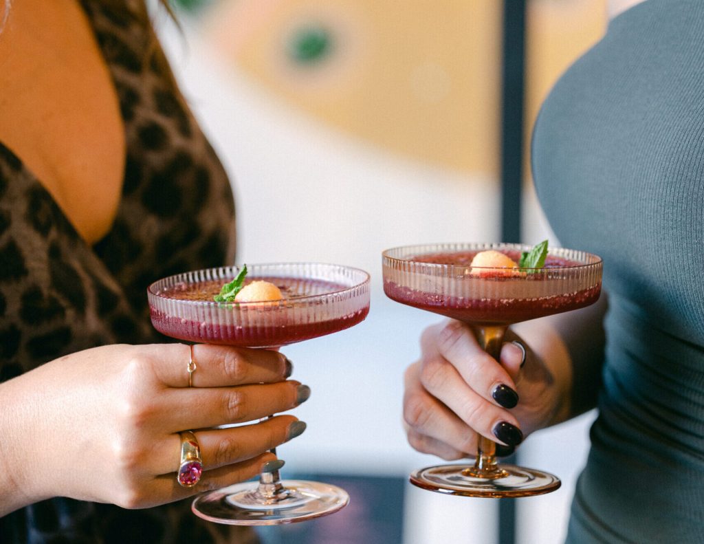 two women holding wine slushes