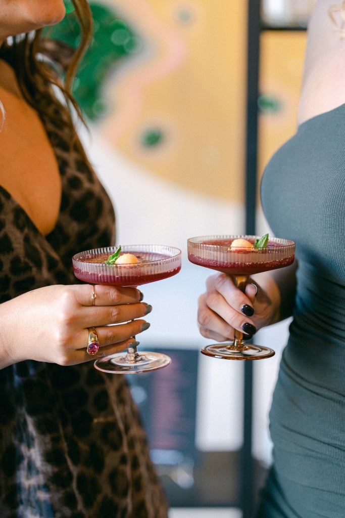 two women holding wine slushes