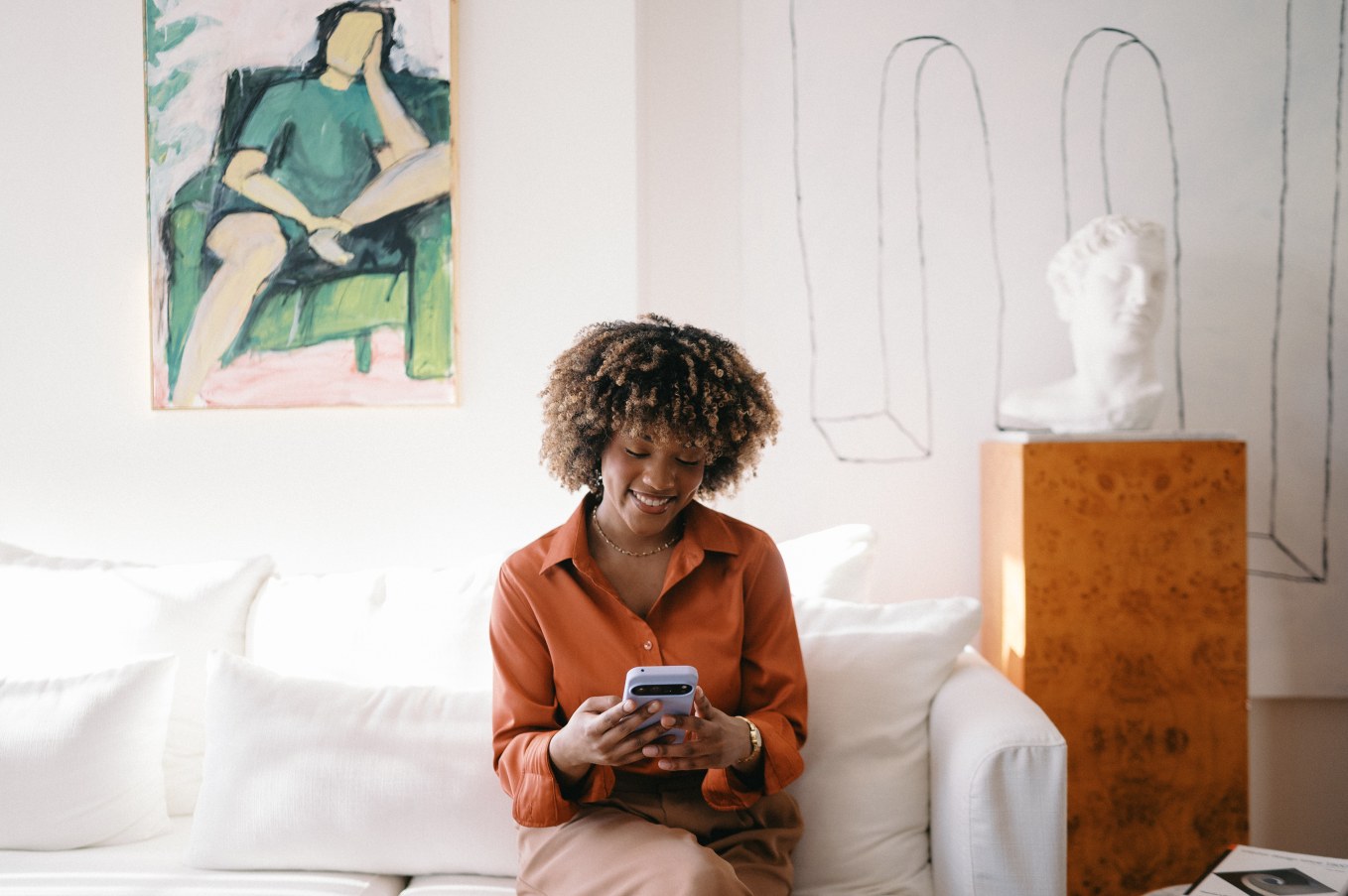 Women sitting on couch with smartphone