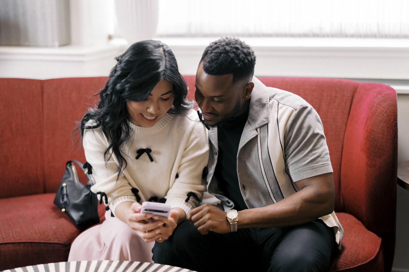 Couple sitting on couch with woman holding cell phone